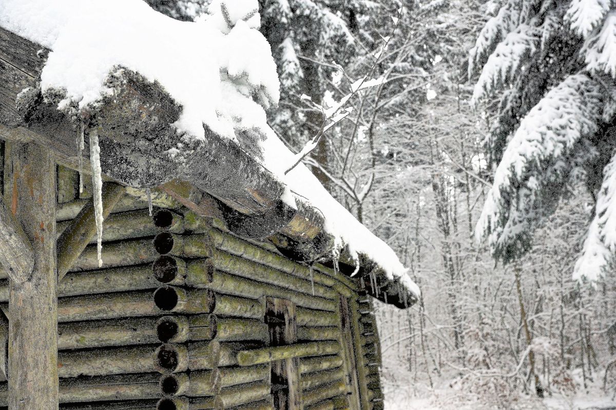 Eiszapfen an der Dachkante eines Hauses im Winter